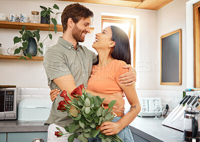 Buy stock photo Happy, couple and hug in house with flowers, bonding together or romantic connection for anniversary. People, dating and love in home with embrace, interracial relationship or roses bouquet for gift.