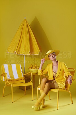 Buy stock photo Portrait, fashion and woman with hat in studio, amber makeup and summer outfit for tropical aesthetic. Trendy color, bold eyeshadow and person with chic wardrobe, vacation style and yellow background