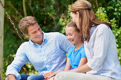 Buy stock photo Happy, parents and relax with daughter at park for love, parental support and bonding together. People, laughing and swing with child, admiration and family connection on vacation getaway in nature