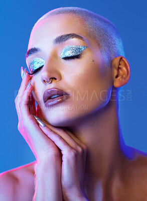 Buy stock photo Woman, makeup and eyeshadow in studio with shimmer, silver glitter and reflection for edgy aesthetic. Creative, person and beauty cosmetics with sparkle, glowing skin and piercing on blue background.
