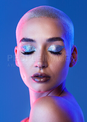 Buy stock photo Woman, makeup and eyeshadow in studio with shine, silver glitter and reflection for edgy aesthetic. Creative, person and beauty cosmetics with sparkle, glowing skin and piercing on blue background.