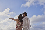 Romantic couple enjoying view together on destination vacation pointing at bright future