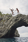 Happy Friends jumping into ocean together having excitement freedom fun action healthy travel vacation adventure
