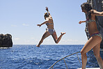 Beautiful Girl Friends jumping into deep blue sea from boat wild free healthy lifestyle on fun travel adventure vacation