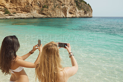 Buy stock photo Travel, picture and phone with friends at beach for social media post, summer vacation and ocean view. Photography, memory and tropical holiday with back of women outdoor for relax and weekend break