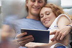 Attractive happy couple using digital computer tablet connected internet social media at home