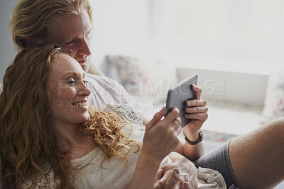Buy stock photo Tablet, relax and couple on bed in home for watching movie, series or show on app together. Happy, bonding and man with woman on digital technology for streaming film in bedroom at house on weekend.