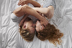 Beautiful man woman couple lying in bed cuddling together in love lifestyle relationship overhead