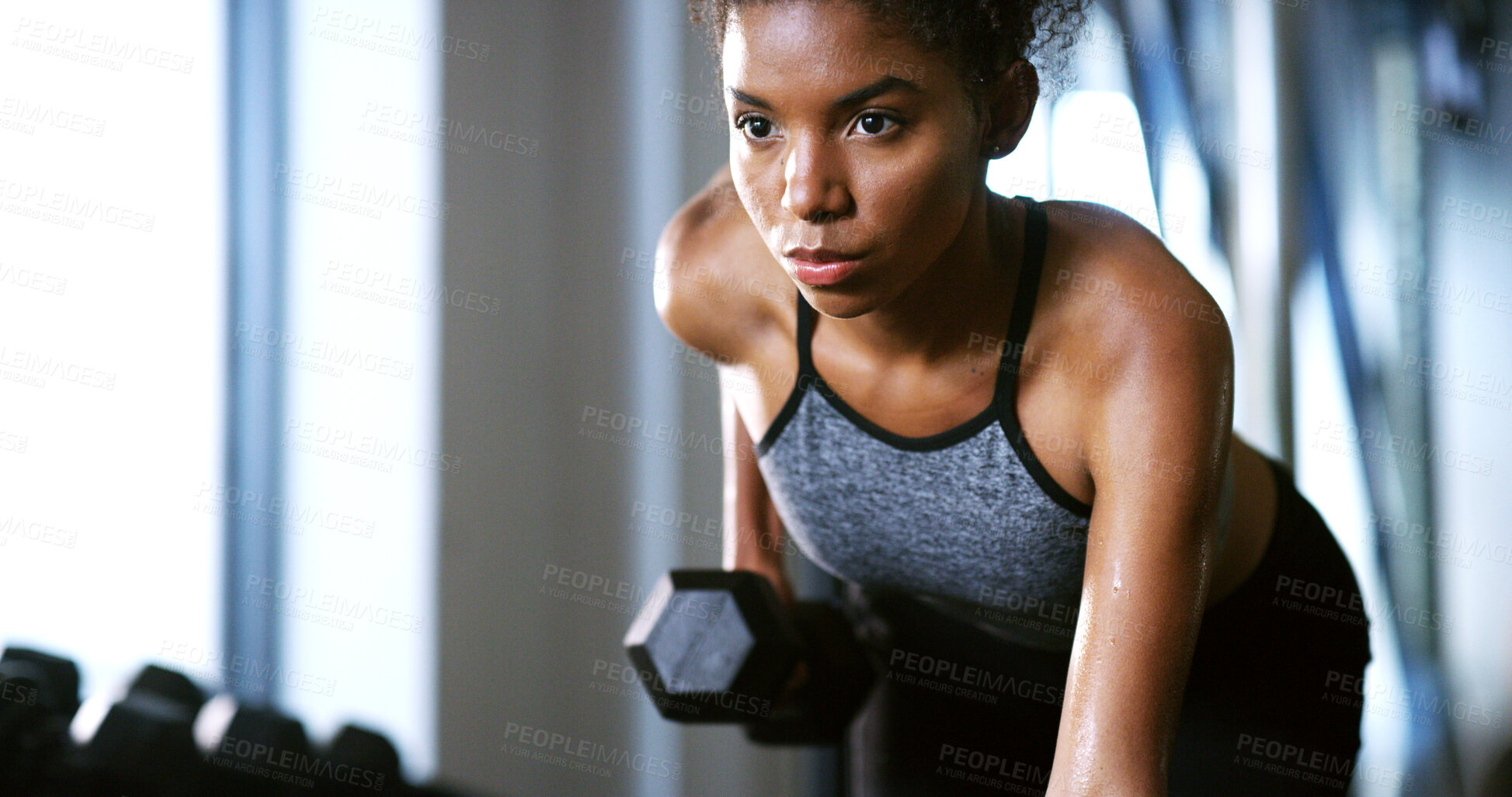 Buy stock photo Fitness, serious or woman in center with dumbbell, weightlifting power or renegade row in bodybuilding. Exercise, sweating or African person with equipment, intense workout or strength in muscle gain