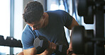 Man, fitness and weightlifting with dumbbell in gym for muscle gain, workout or indoor exercise. Active, male person or lifting with weight or arm for bicep curl or strength training in health club