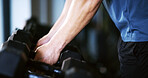 Man, hands or weightlifting with dumbbells on rack in gym for workout preparation or exercise. Active, male person or getting ready with weight or equipment for muscle gain or strength in health club