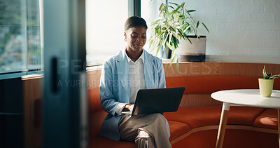 Buy stock photo Black woman, laptop and typing by window in office lounge for notes, report or property development. African person, realtor or happy on sofa with proposal, computer or decision at real estate agency