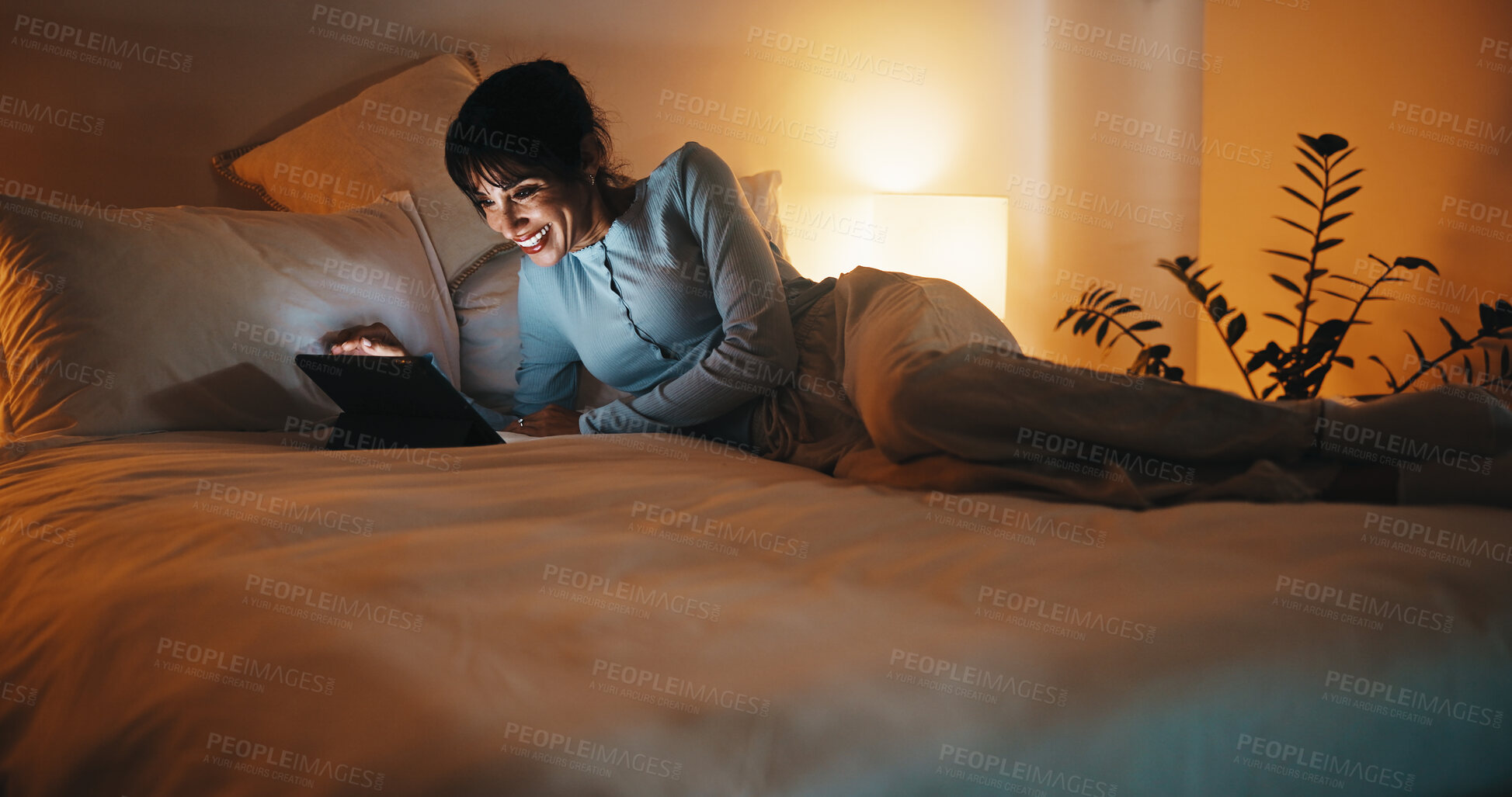Buy stock photo Bed, woman and streaming on tablet at night for binge watching series, funny episode or relax. Weekend, mature person or laugh with tech in home for comedy film, tv show subscription or entertainment