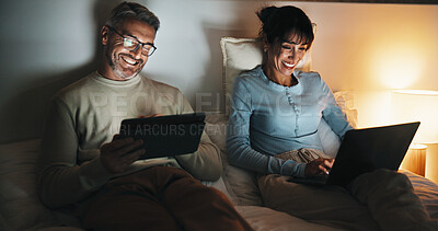 Buy stock photo Bed, couple and streaming on tech at night for binge watching, bonding and funny tv show. Laptop, mature people or laugh with tablet in home for comedy film, web entertainment or healthy relationship