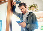 One fit young caucasian man listening to music with earphones from a cellphone while taking a break from exercise at home. Guy texting and using fitness apps online while browsing social media and watching workout tutorials