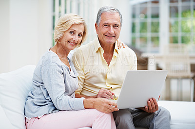 Buy stock photo Portrait of a senior couple using a laptop while relaxing in the lounge