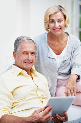 Buy stock photo Portrait of a senior couple using a tablet while relaxing in their lounge