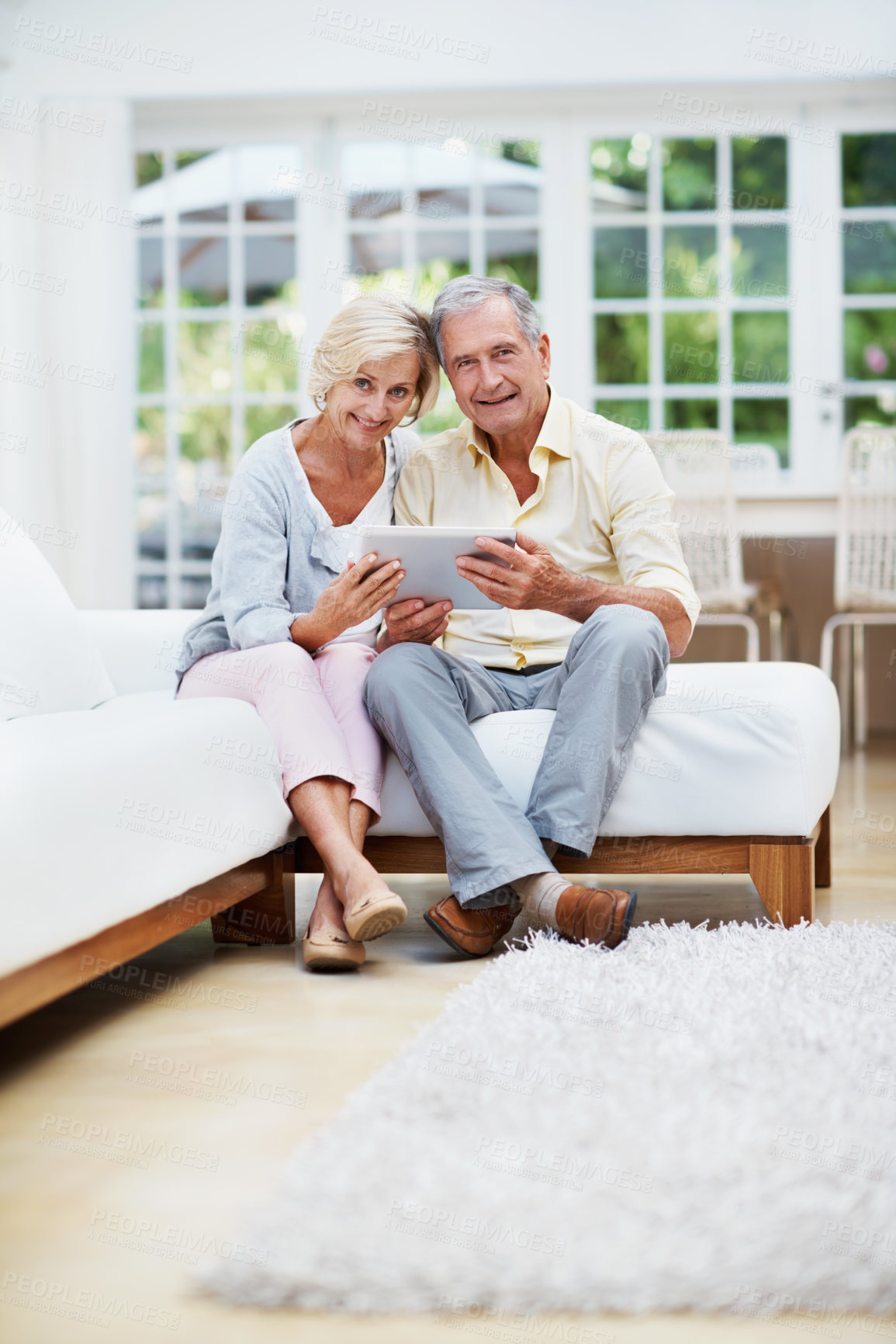 Buy stock photo Portrait, tablet and relax with old couple on sofa for retirement home review, planning and support. Senior living research, smile and connection with elderly man and woman in lounge of house
