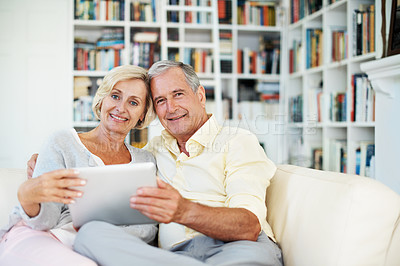 Buy stock photo Portrait of a senior couple reading an ebook together in their study at home