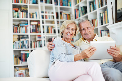 Buy stock photo Portrait of a senior couple reading an ebook together in their study at home