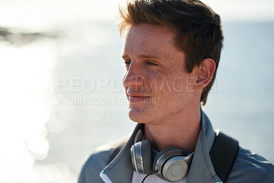 Buy stock photo Man, think and student at beach on spring break, smile and explore with sunshine space. College person, sightseeing vision or term holiday with day at coastline, headphones and travel view in Miami