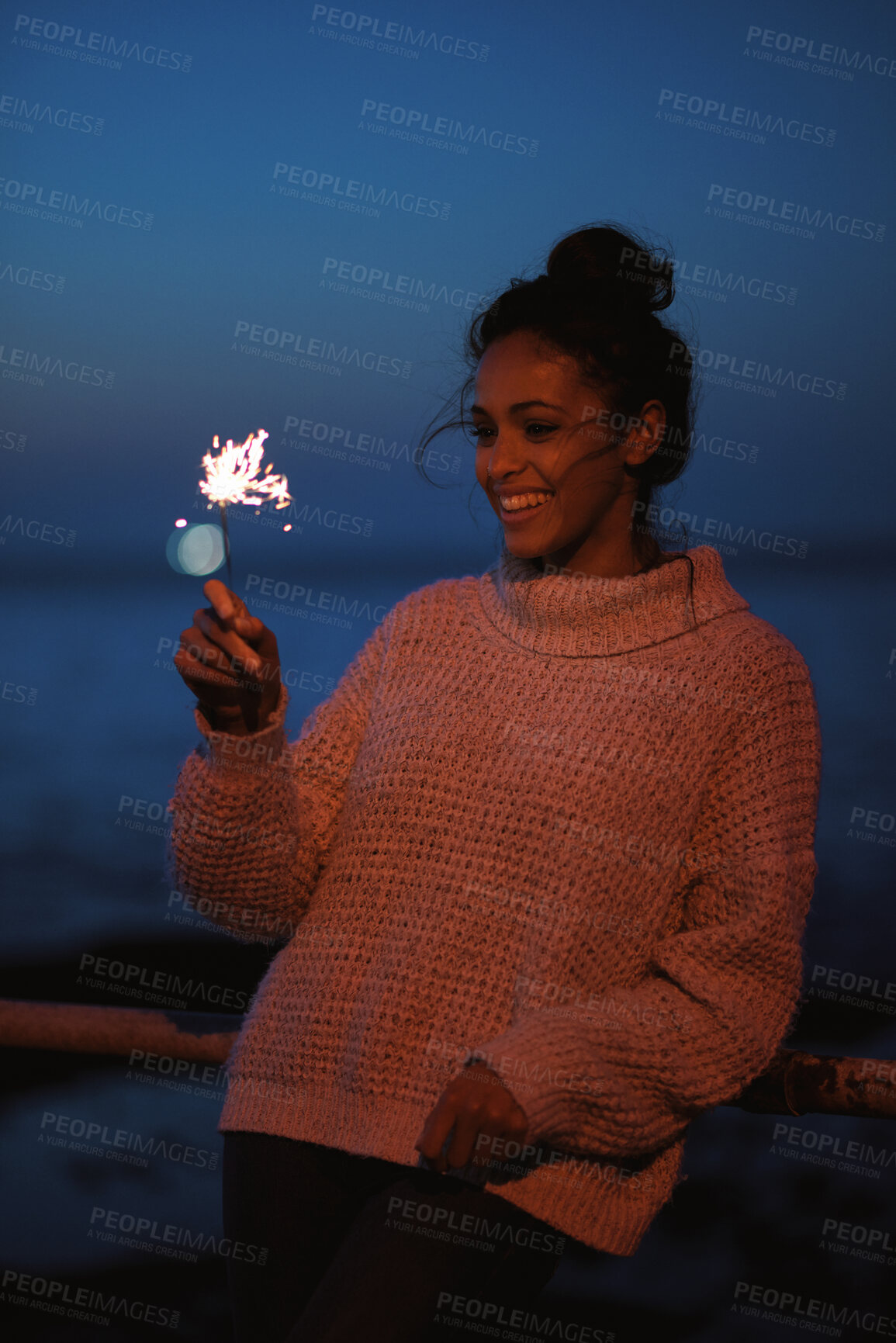 Buy stock photo Smile, woman and sparkler at beach for celebration, new year and travel on vacation at night. Happy, person and fireworks at promenade party by ocean, festive season and glow on holiday outdoor