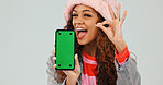 Wink, promotion and woman with phone, green screen and okay sign for discount or marketing in studio. White background, mockup space and happy person with mobile display, portrait and advertising
