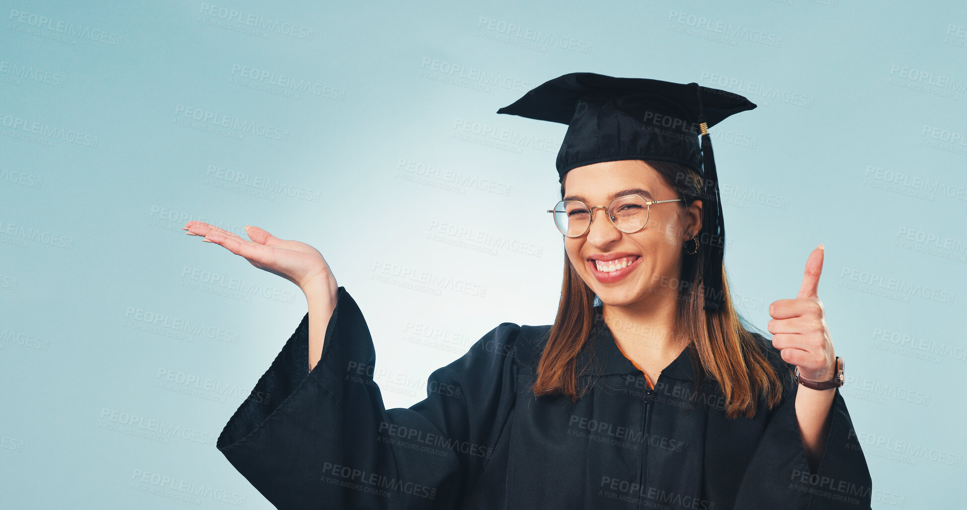 Buy stock photo Thumbs up, graduation and portrait of woman in studio for scholarship promotion, space and pride. Graduate, announcement and university with person on blue background for study success and education