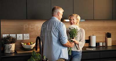Buy stock photo Love, flowers and senior couple in home for support, comfort or bonding together in kitchen. Smile, commitment and elderly man with woman for gift with marriage, anniversary and bouquet in apartment