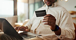 Hands, man and laptop with credit card for online shopping, payment or banking on sofa in home. Male person, user or mobile shopper with debit or computer for ecommerce or remote purchase in house