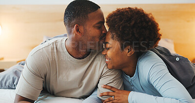 Buy stock photo Forehead, kiss and smile with black couple in bed at apartment together for bonding, connection or rest. Affection, love and wake up with happy people in bedroom of home for break, holiday or romance