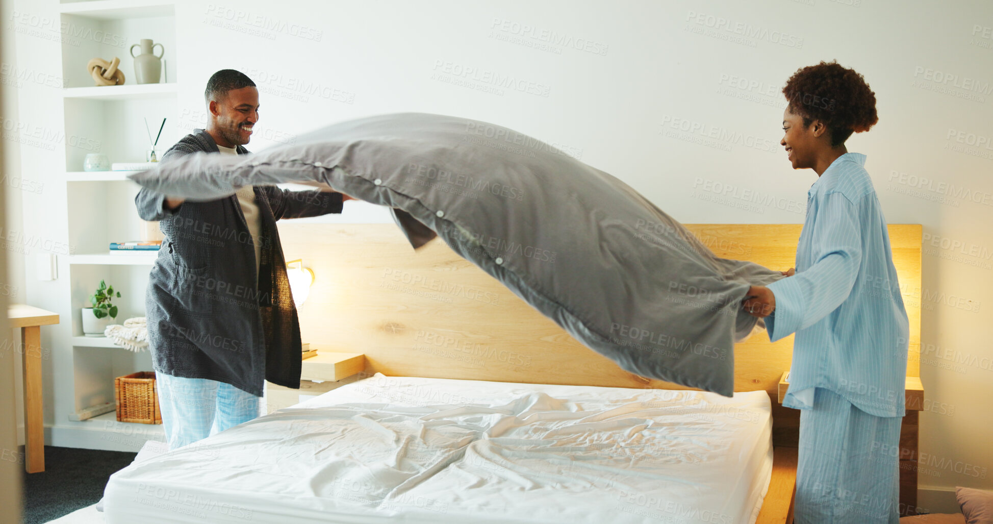 Buy stock photo Black couple, making bed and cleaning in home with help, support and partnership with smile. Woman, man and bedroom with sheet, blanket or duvet for housekeeping with teamwork for hygiene in house