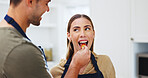 Happy, couple and feed fruit in kitchen with healthy diet, bonding together and love for wellness. Married people, taste strawberry and eating in home with nutrition, support or care for relationship
