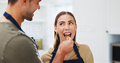 Buy stock photo Happy, couple and feed fruit in kitchen with healthy diet, bonding together and love for wellness. Married people, taste strawberry and eating in home with nutrition, support or care for relationship