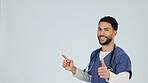 Nurse, pointing and portrait with happy man or thumbs up in studio for advertising or option. Male person, healthcare worker or smile with like emoji or yes sign for choice or marketing on space