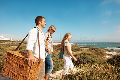 Buy stock photo Holiday, travel and love with family at beach for summer vacation, bonding and tropical adventure. Getaway, care and picnic basket with parents and child walking outdoor for support on trip together