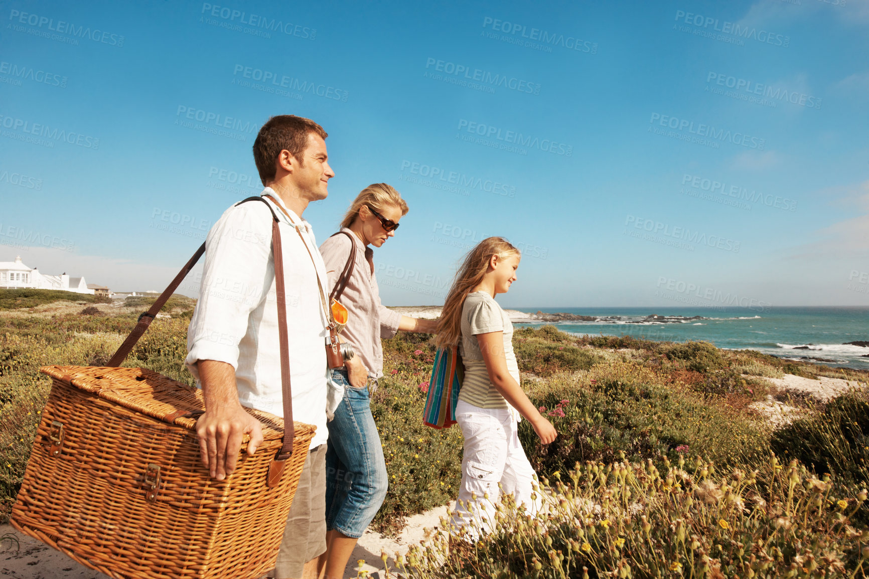 Buy stock photo Holiday, travel and love with family at beach for summer vacation, bonding and tropical adventure. Getaway, care and picnic basket with parents and child walking outdoor for support on trip together