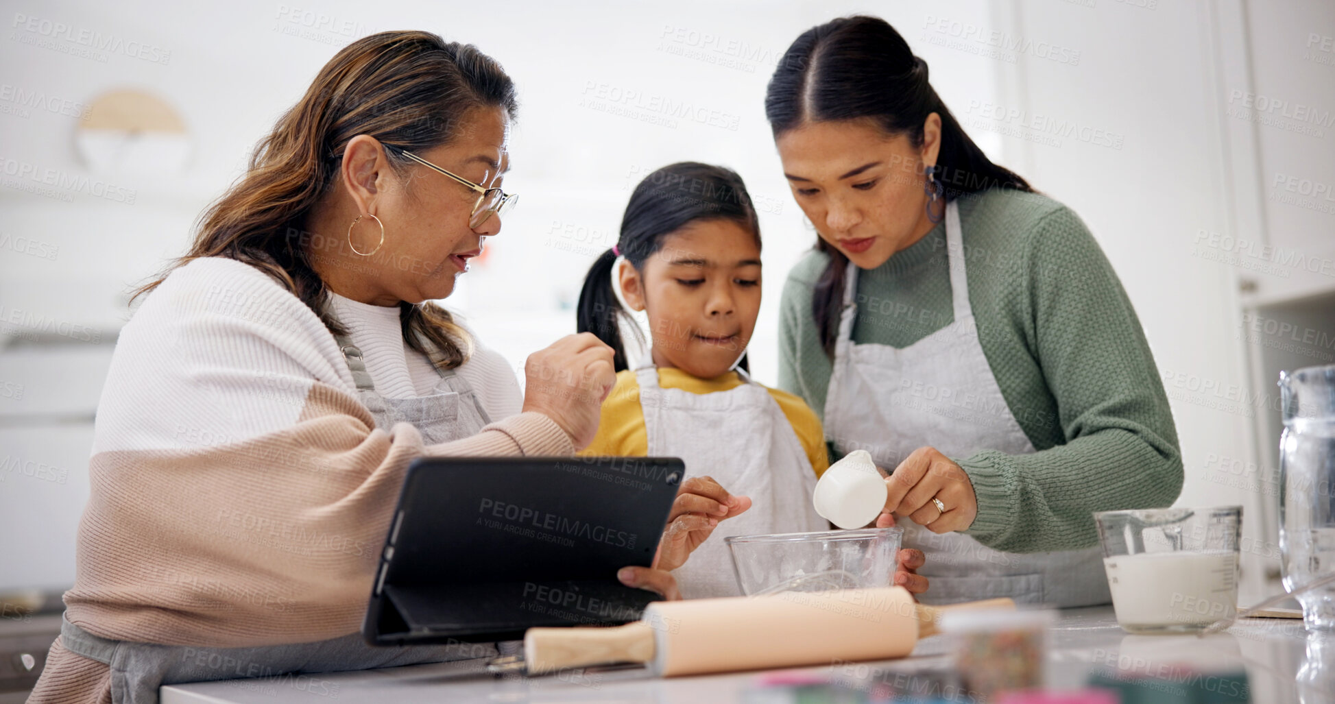Buy stock photo Baking, old woman and child with tablet in kitchen, talking or instructions for dessert preparation. People, online and meal prep with grandma, tips and learning culinary skills with tech in home
