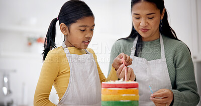 Buy stock photo Kid, mother and candles on birthday cake for baking at home, celebration and special day. Parent, decoration and girl with rainbow dessert at party for help, preparation or learning in family kitchen