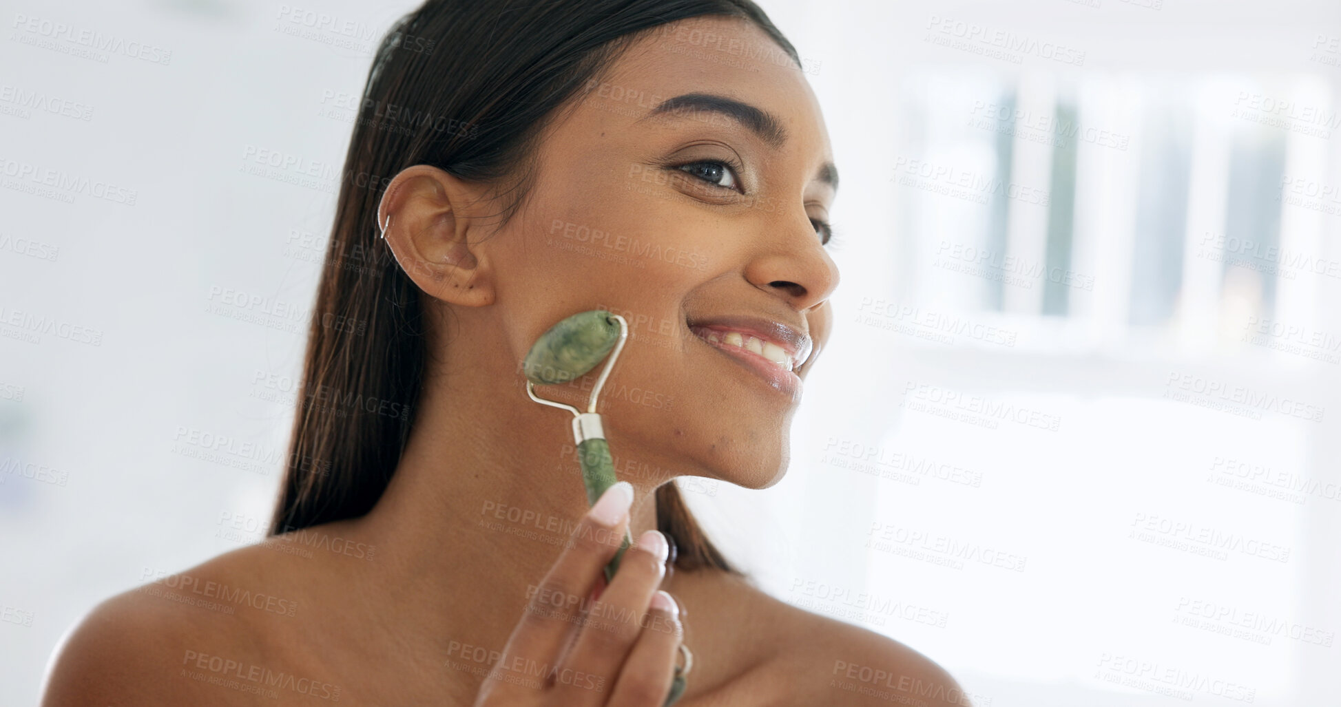Buy stock photo Smile, skincare or woman with jade roller in home, lymphatic drainage or beauty with glow. Bathroom, happy person and tool for facial massage for health, shine or dermatology benefits in morning