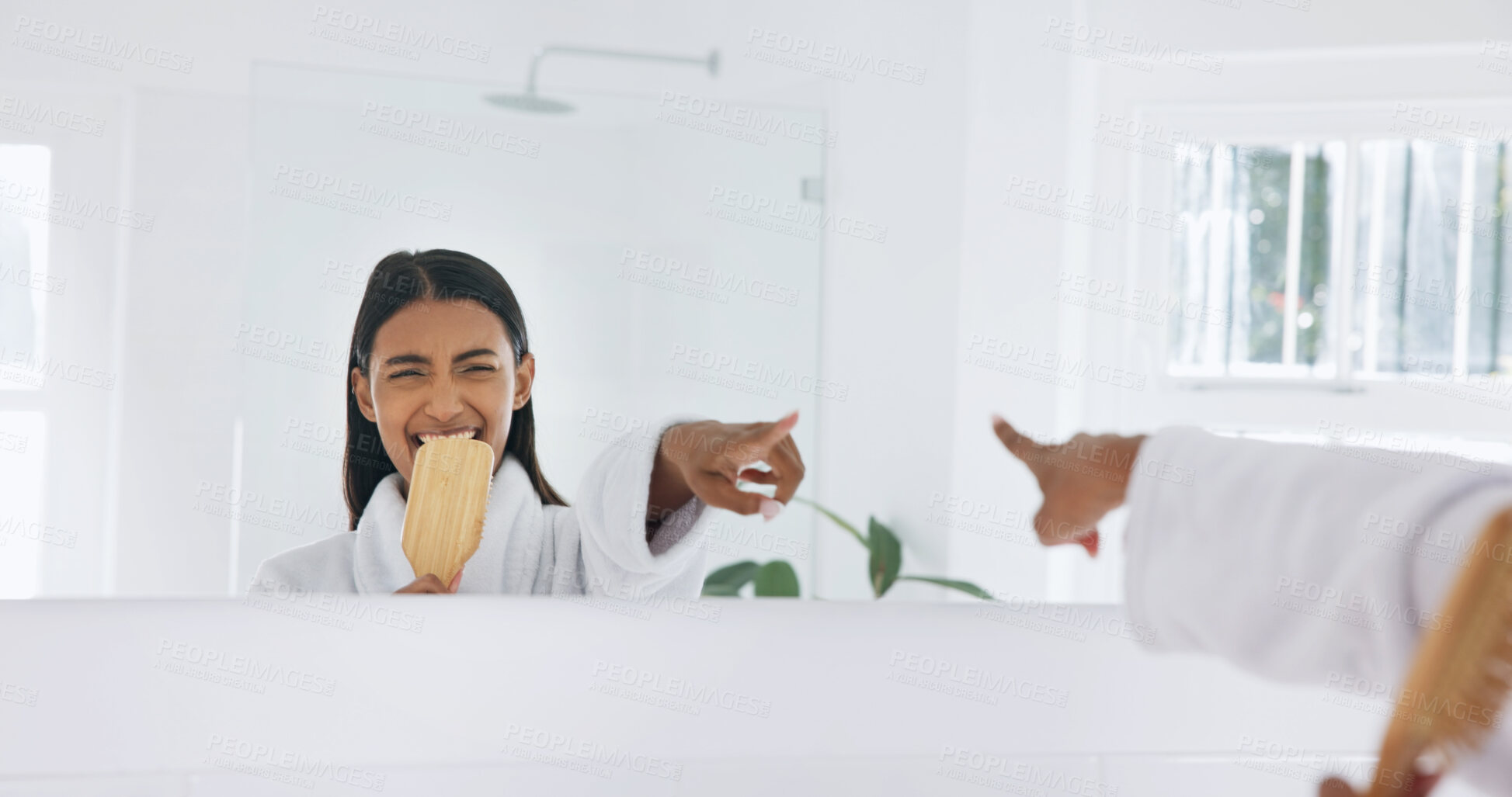 Buy stock photo Woman, happy and singing in mirror with brush for morning routine, fun and hair care in bathroom. Bamboo hairbrush, pointing and reflection with person in home for beauty, karaoke and getting ready