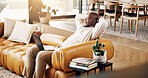 Laptop, remote work and thinking with black man on sofa in home living room for planning or research. Computer, hands behind head and smile with person in apartment for report as freelance employee