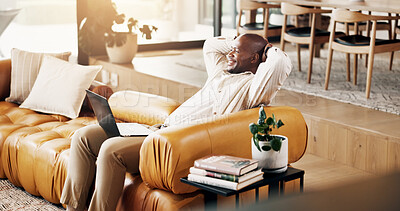 Buy stock photo Laptop, remote work and thinking with black man on sofa in home living room to complete research. Computer, hands behind head and smile with person in apartment to finish report as freelance employee