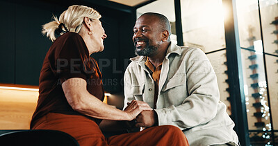 Buy stock photo Holding hands, love and smile with interracial couple in home living room for bonding or security. Affection, happy and relax with mature people on sofa in apartment for support, trust or wellness