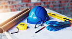 Construction, blueprint and helmet with tools on table for renovation, building design or planning. Architecture, equipment and floor plan on site for real estate development, safety gear or drafting