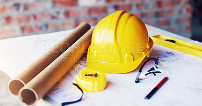 Buy stock photo Helmet, construction and tools in empty office for engineering, blueprint design and tape measure. Architecture, equipment or safety ppe at building site with development paperwork, layout or drawing