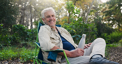 Buy stock photo Senior, portrait or happy man in nature for camping, outdoor holiday or vacation in wilderness. Elderly, male person or relax with smile, chair or bottle for retirement or weekend getaway on campsite