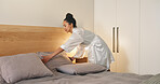 Pillow, morning and woman making bed in hotel for daily routine, fresh fabric or maintenance. Change, cleaning and tidy with person in bedroom of accommodation for chores, housework or responsibility