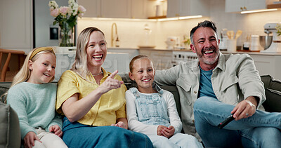 Buy stock photo Parents, kids and watching tv in house with laugh, family time or bonding together for funny cartoon. Happy people, father and mother point on sofa with girl children, comedy show or streaming movie.