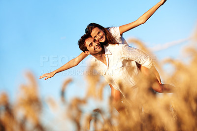 Buy stock photo Couple, flying and piggyback in nature, sky and playful with partner on weekend, bonding or together. Portrait, freedom and happy people on summer vacation, connection and low angle on adventure